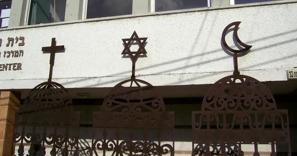 3 wire gates with the symbols for Christianity, Judaism, and Islam at the top of each one