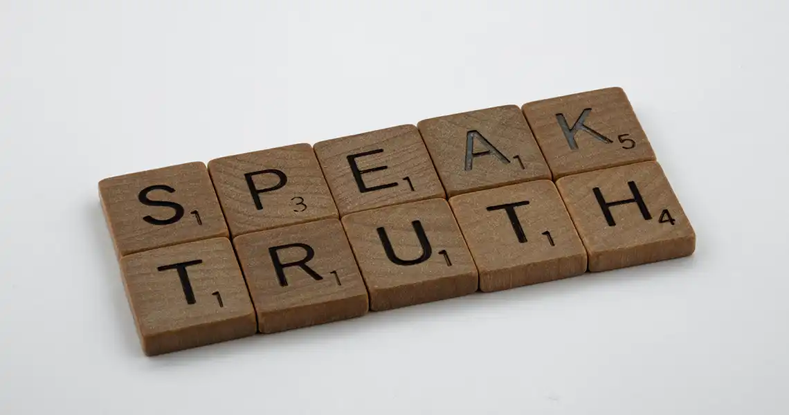 Scrabble tiles — small wooden tiles with letters on them — spelling out speak the truth